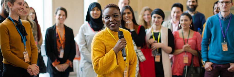 A university staff member speaking to a gathering of teachers and students.
