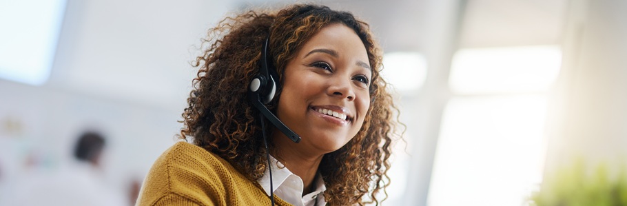 A smiling Clearing phoneline adviser wearing a headset.