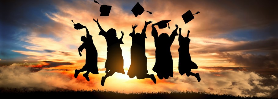 An image of students with graduation hats jumping into the sunset