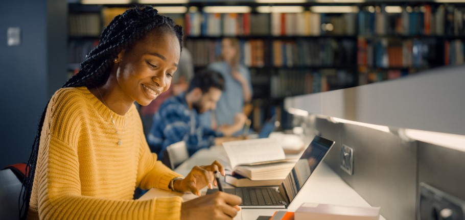 A student working on a personal statement using a laptop