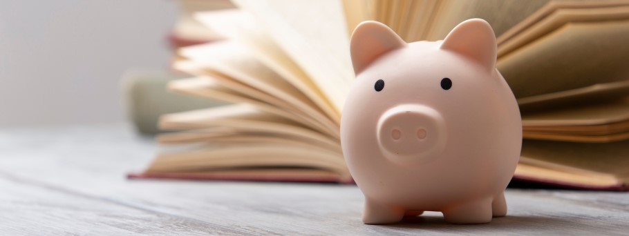 Image of a student studying by a piggy bank