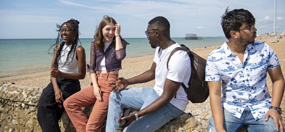 Image of four students on a Brighton beach