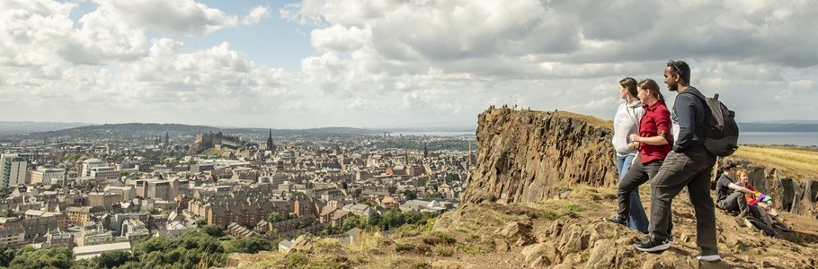 A group of students looking at Edinburgh from a beautiful hill.